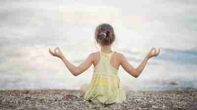 Young girl with ADHD sits on a beach